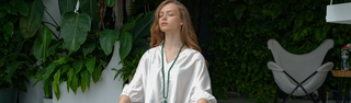 Woman practising meditation with O. Live Love jewelry on.