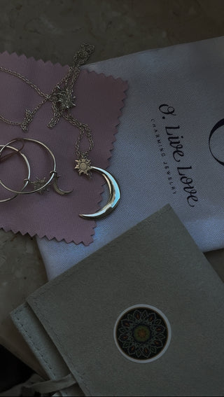 Sun & Moon Layered Necklace shown on a table with the packaging from O. Live Love.